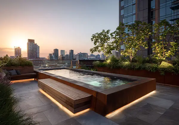 Dachterrasse mit Cityblick, Holzbank und eingelassenem Becken bei Sonnenuntergang