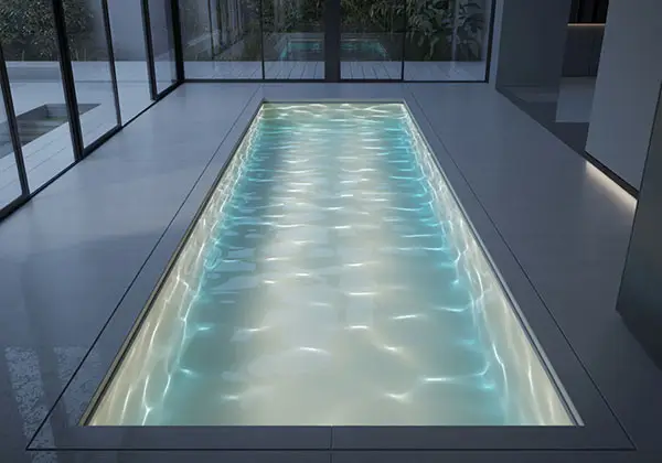 Schmaler Indoorpool mit Glasfront und Gartenblick, Lichtreflexionen im Wasser