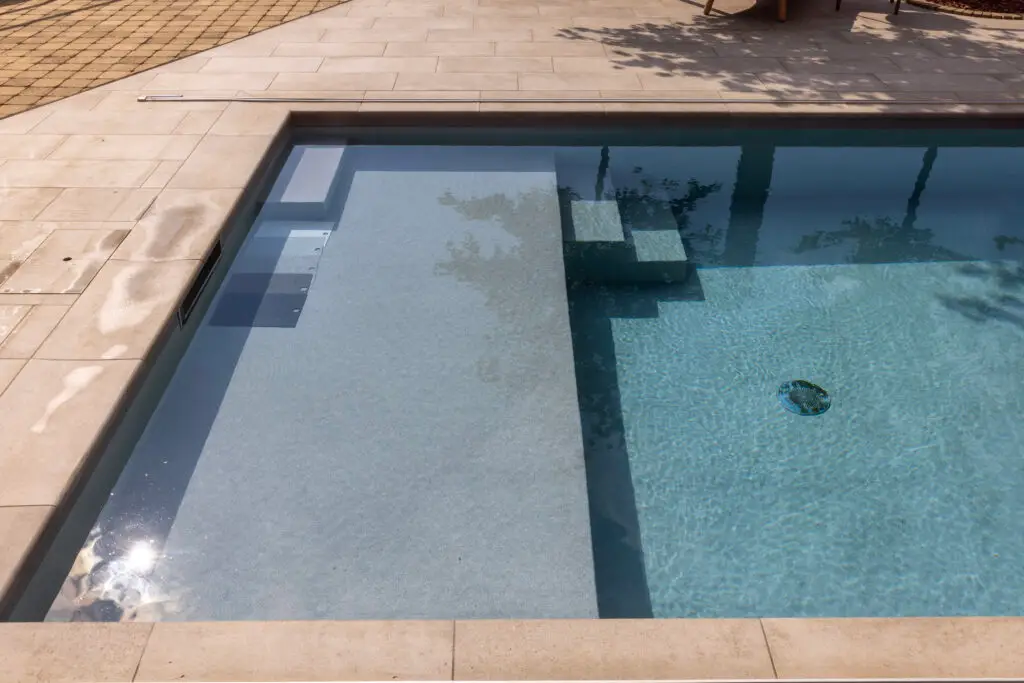 Flacher Einstieg mit breiter Stufe und Sitzbank im Pool