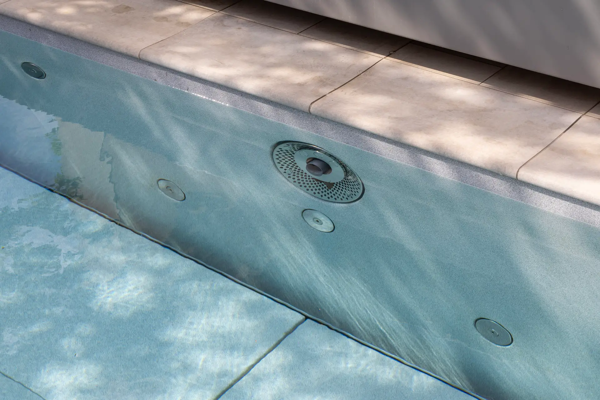 Pooldetail mit Skimmer und mehreren Einströmdüsen unter Wasser