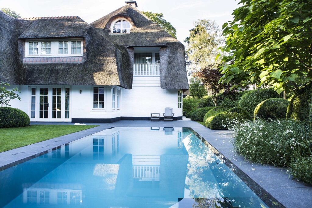 Traditionelles Wohnhaus mit modernem Pool im Grün