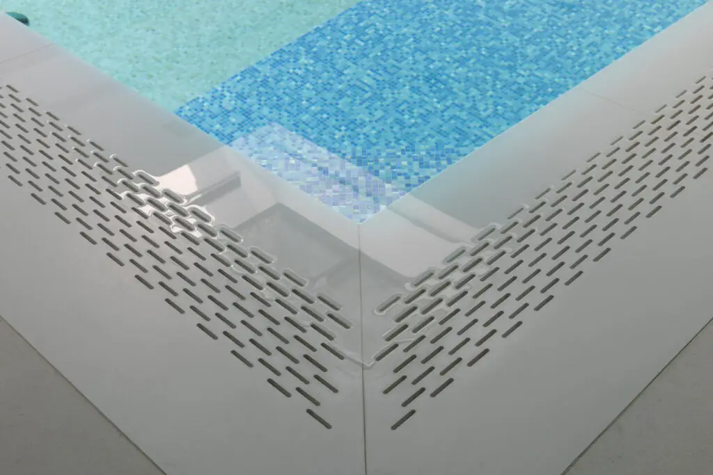 Überlaufrinne mit weißer Abdeckung und blauem Mosaik im Poolbecken