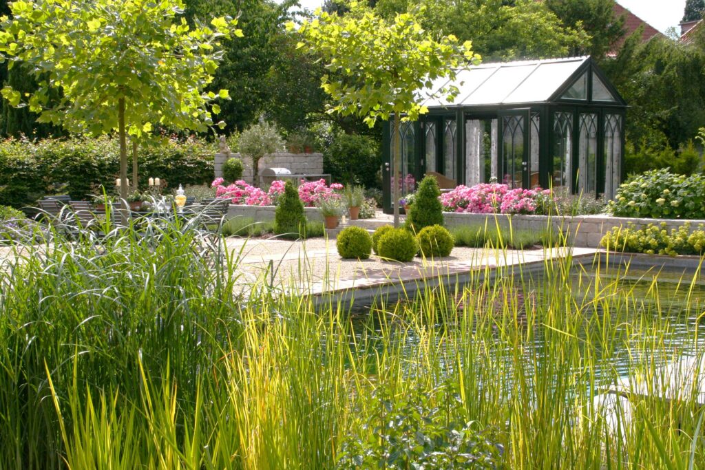 Garten mit Naturpool, Rosenbeeten und verglastem Gartenhaus