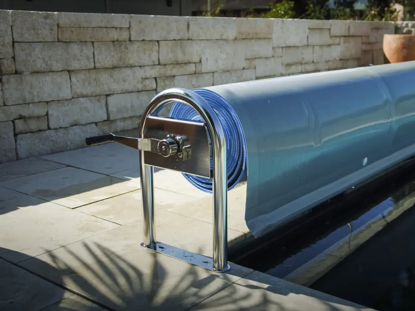 Swimroll Poolabdeckung mit manuellem Aufrollsystem und Edelstahlhalterung am Beckenrand